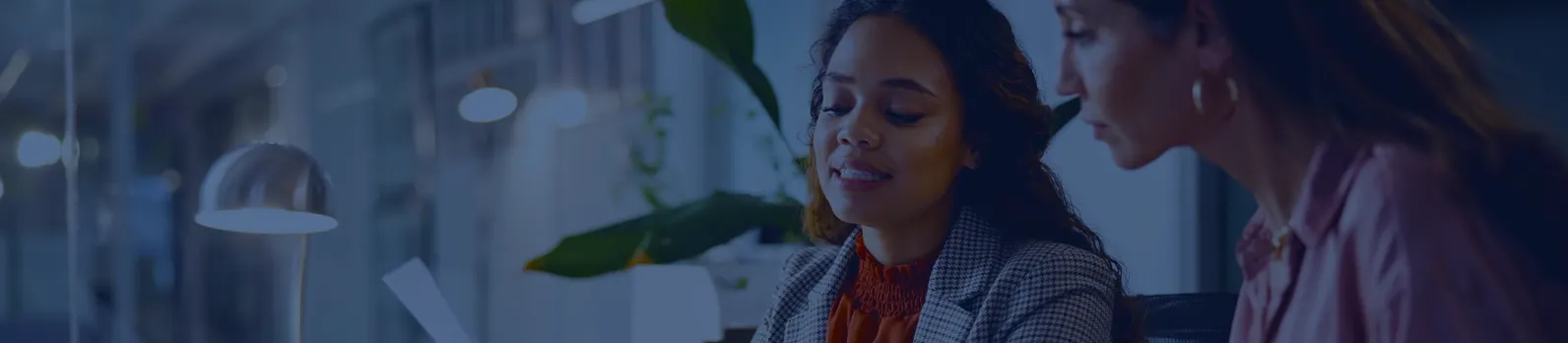 Deux femmes en discussion dans un bureau moderne et lumineux