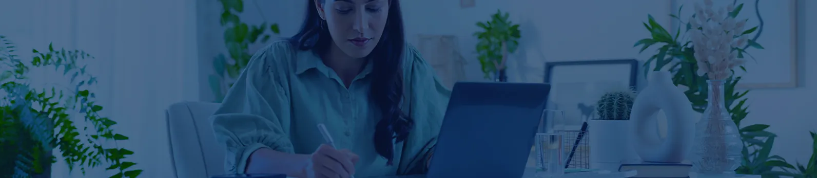 Femme travaillant sur un ordinateur portable et prenant des notes